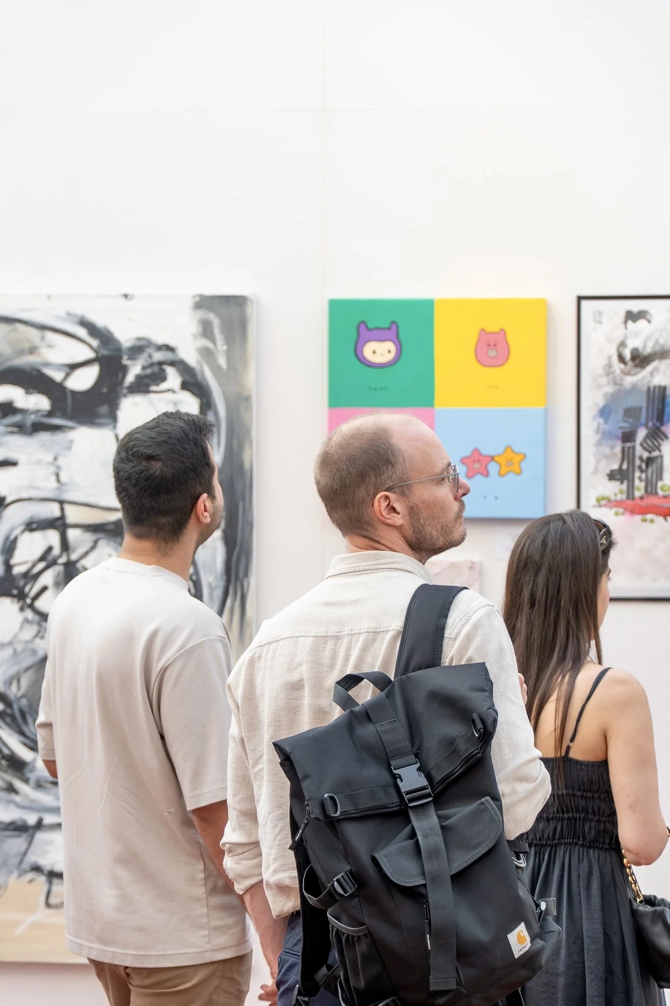 Visitors standing before paintings in the Holy Art London gallery